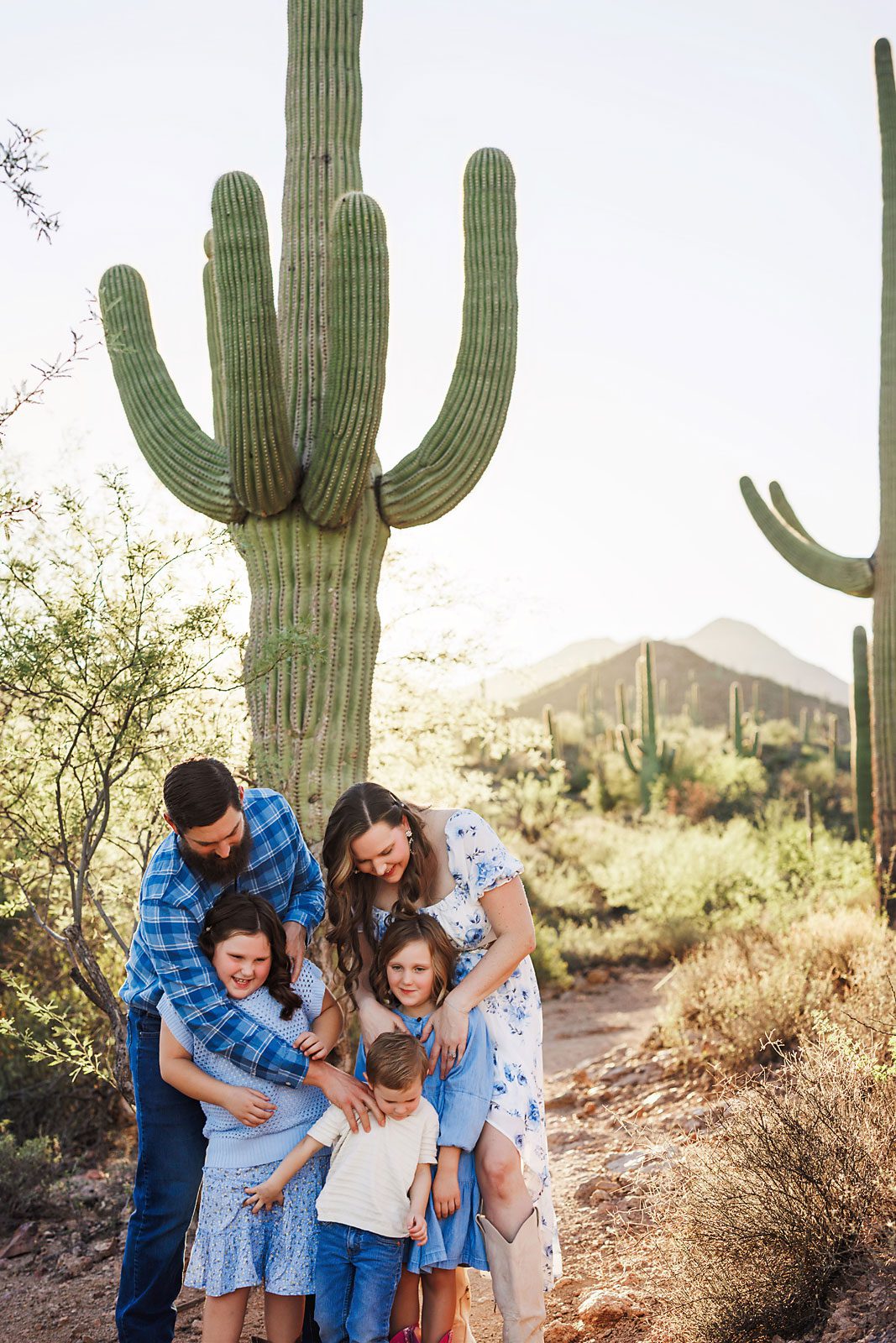 outdoor family photography session featuring parents and children sharing a candid moment in natural light